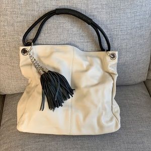 White leather bag with black handle and tassles